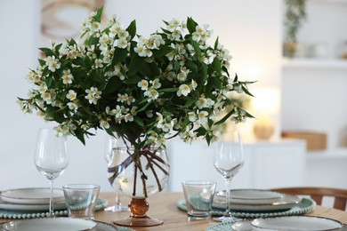 Photo of Bouquet of beautiful jasmine flowers on dining table indoors
