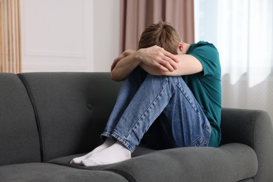 Photo of Man suffering from paranoia on sofa at home