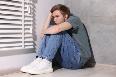 Photo of Man suffering from paranoia near window at home