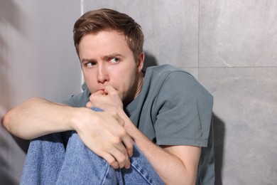 Photo of Scared man suffering from paranoia at home