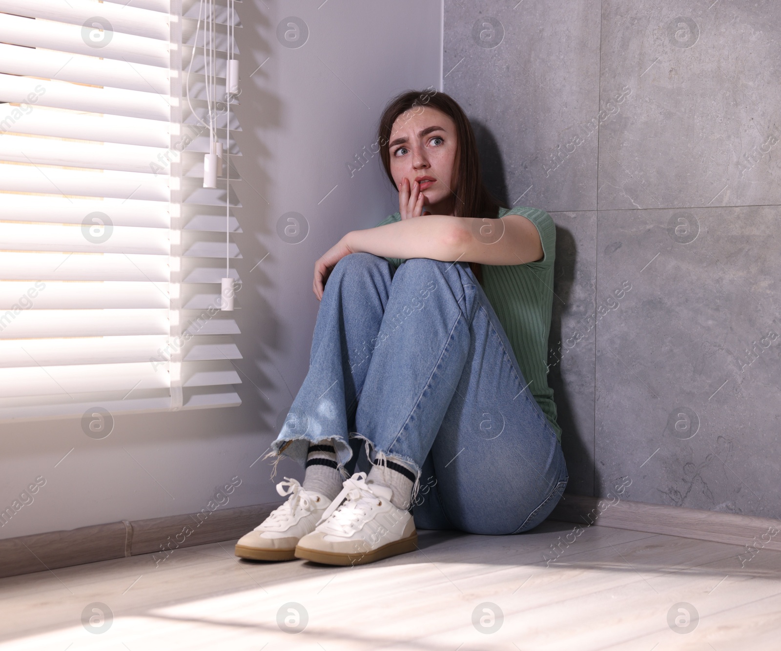 Woman suffering from paranoia near window at home Photo of Woman suffering from paranoia near window at home