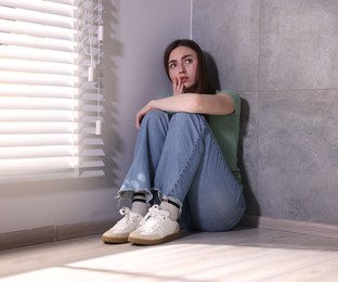 Photo of Woman suffering from paranoia near window at home