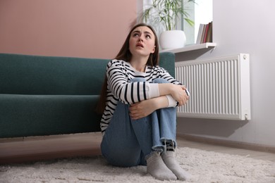 Photo of Woman suffering from paranoia on floor at home