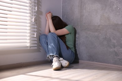 Photo of Woman suffering from paranoia near window at home