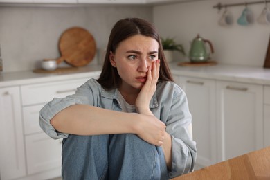 Photo of Worried woman suffering from paranoia in kitchen