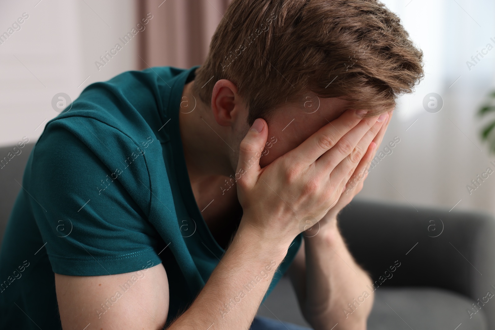 Man suffering from paranoia on sofa at home Photo of Man suffering from paranoia on sofa at home