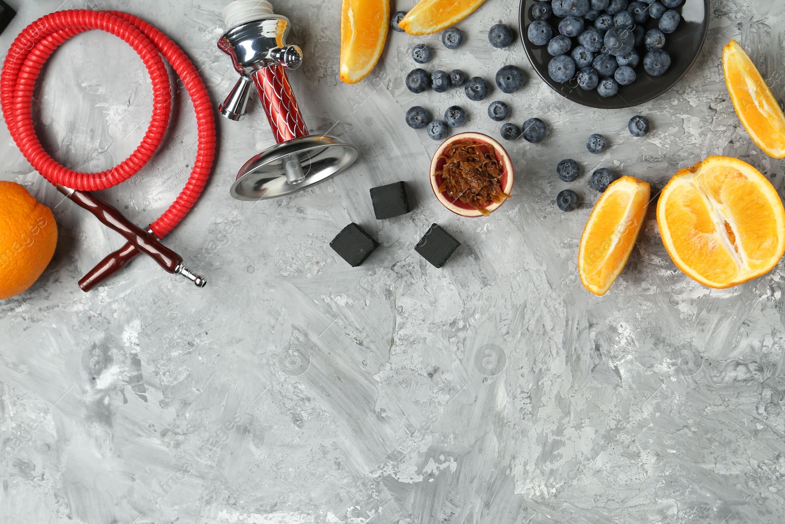 Photo of Hookah, coal and fresh fruits on grey table, flat lay. Space for text