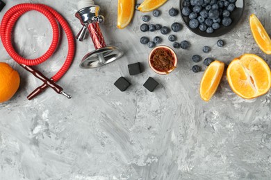 Photo of Hookah, coal and fresh fruits on grey table, flat lay. Space for text