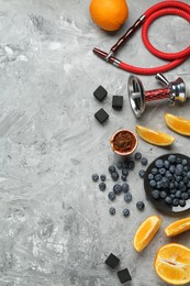 Photo of Hookah, coal and fresh fruits on grey table, flat lay. Space for text