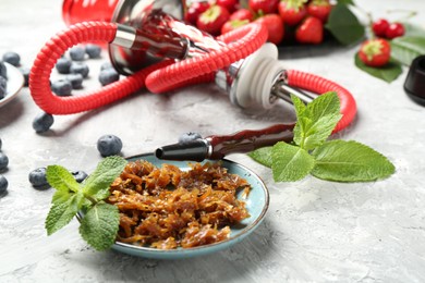 Photo of Hookah and fresh fruits on grey table, closeup
