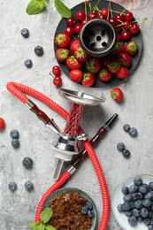 Photo of Hookah and fresh fruits on grey table, flat lay