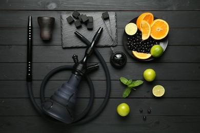 Photo of Hookah, coal and fresh fruits on black wooden table, flat lay