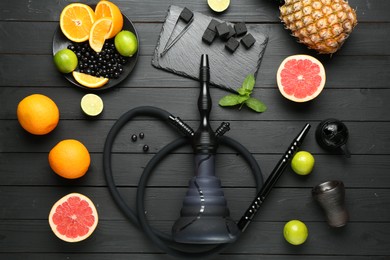 Photo of Hookah, coal and fresh fruits on black wooden table, flat lay