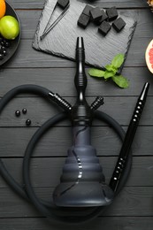 Photo of Hookah, coal and fresh fruits on black wooden table, flat lay