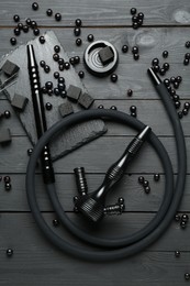 Photo of Hookah, coal and currants on black wooden table, flat lay