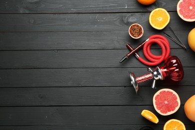 Photo of Hookah and fresh fruits on black wooden table, flat lay. Space for text