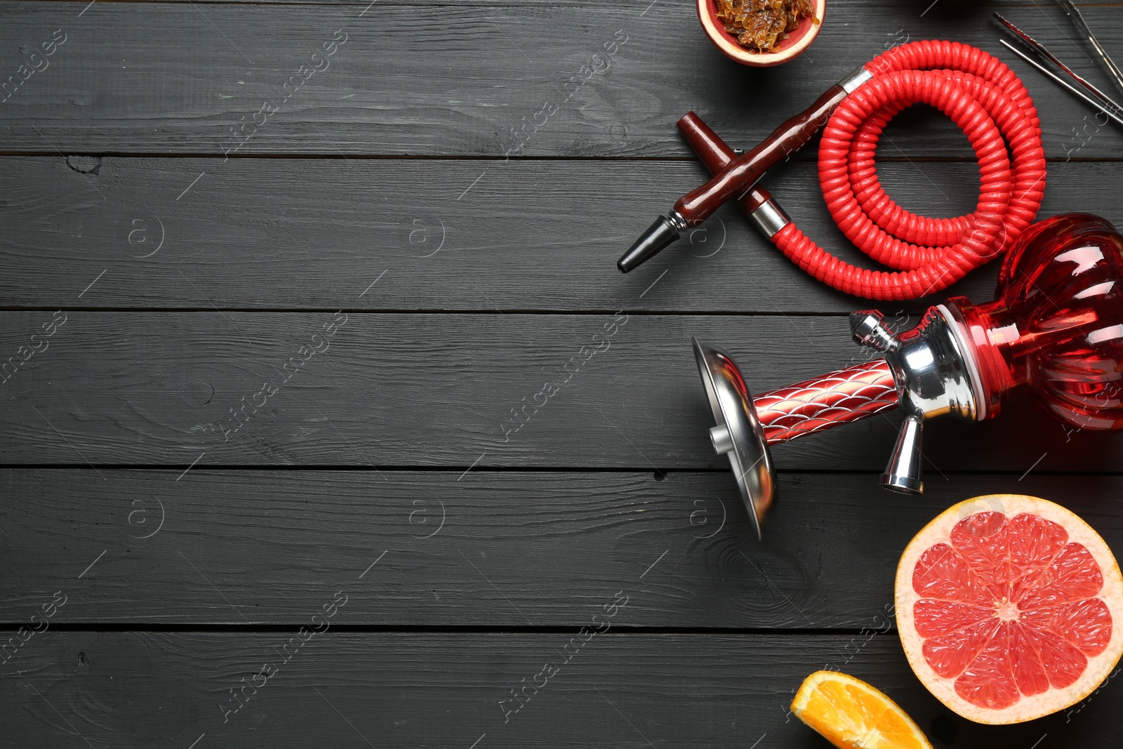 Photo of Hookah and fresh fruits on black wooden table, flat lay. Space for text