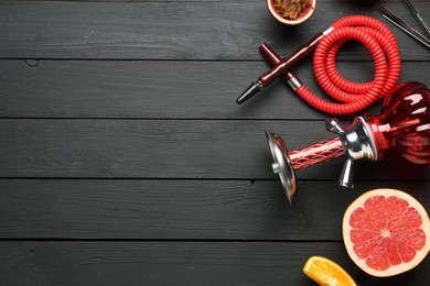 Photo of Hookah and fresh fruits on black wooden table, flat lay. Space for text