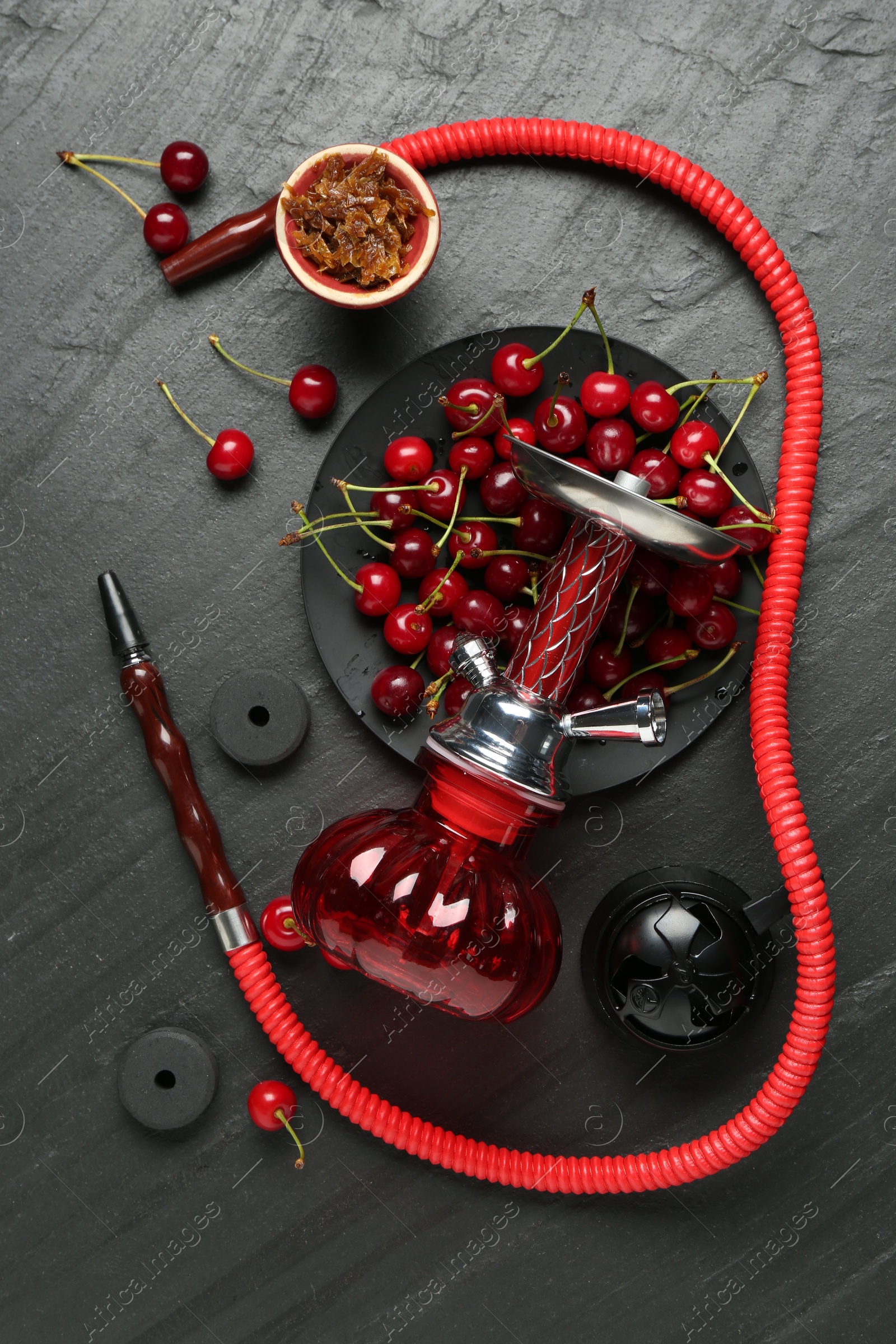 Photo of Hookah and cherries on black table, flat lay