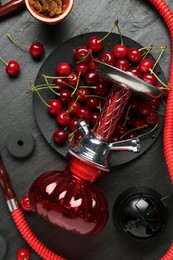 Photo of Hookah and cherries on black table, flat lay