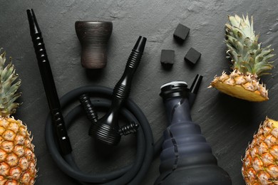 Photo of Hookah, coal and pineapples on black table, flat lay