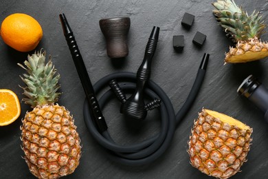 Photo of Hookah, coal and fresh fruits on black table, flat lay
