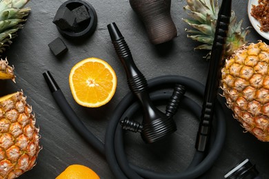 Photo of Hookah, coal and fresh fruits on black table, flat lay
