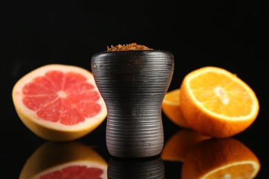 Photo of Hookah bowl with smoke and fruits on black table, closeup