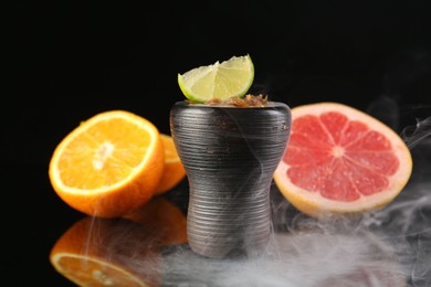 Photo of Hookah bowl with smoke and fruits on black table, closeup