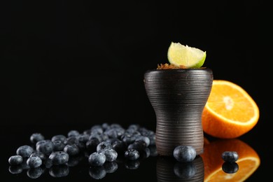 Photo of Hookah bowl with smoke and fruits on black table, closeup. Space for text