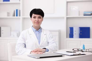 Photo of Portrait of professional ophthalmologist at white table in clinic