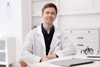 Photo of Portrait of professional ophthalmologist at white table in clinic