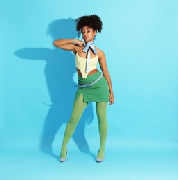 Photo of Fashionable portrait of beautiful Brazilian woman in stylish outfit on light blue background
