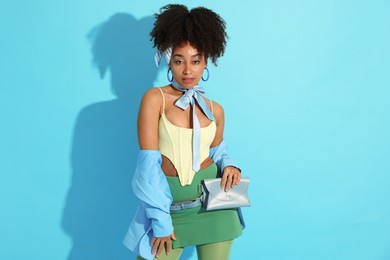 Photo of Fashionable portrait of beautiful Brazilian woman in stylish outfit on light blue background