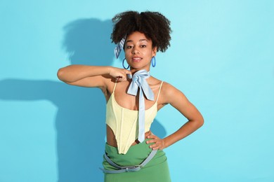 Photo of Fashionable portrait of beautiful Brazilian woman in stylish outfit on light blue background