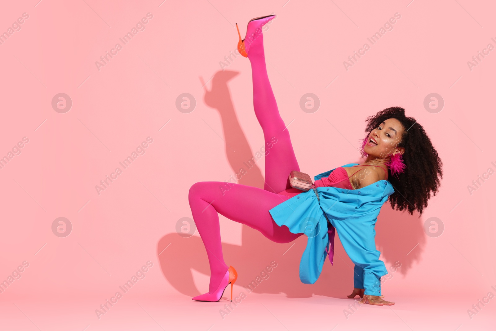Fashionable portrait of beautiful Brazilian woman in stylish outfit on pink background Photo of Fashionable portrait of beautiful Brazilian woman in stylish outfit on pink background