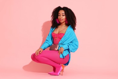 Photo of Fashionable portrait of beautiful Brazilian woman in stylish outfit on pink background