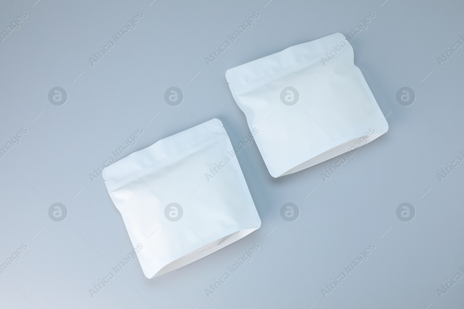 Two zipper stand-up pouches on light grey background, flat lay. Mockup for design Photo of Two zipper stand-up pouches on light grey background, flat lay. Mockup for design