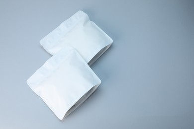 Photo of Two zipper stand-up pouches on light grey background, above view. Mockup for design