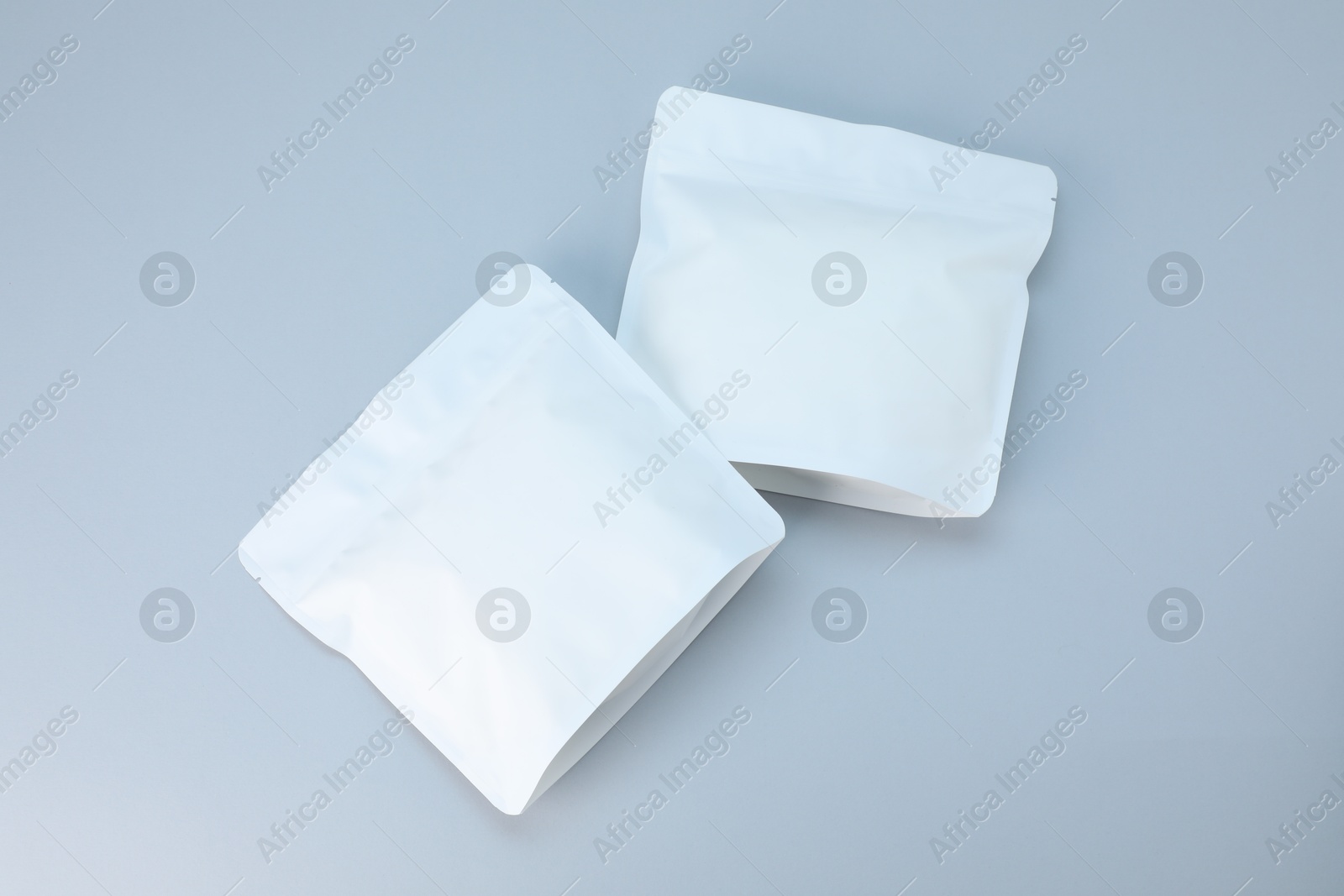 Two zipper stand-up pouches on light grey background, flat lay. Mockup for design Photo of Two zipper stand-up pouches on light grey background, flat lay. Mockup for design