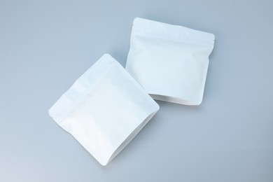 Photo of Two zipper stand-up pouches on light grey background, flat lay. Mockup for design