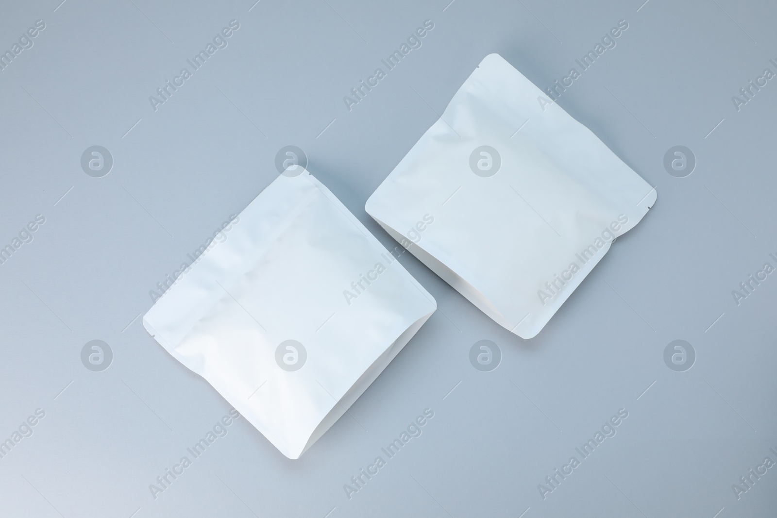 Two zipper stand-up pouches on light grey background, flat lay. Mockup for design Photo of Two zipper stand-up pouches on light grey background, flat lay. Mockup for design