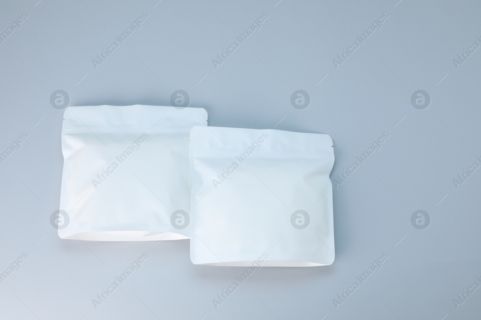 Two zipper stand-up pouches on light grey background, flat lay. Mockup for design Photo of Two zipper stand-up pouches on light grey background, flat lay. Mockup for design