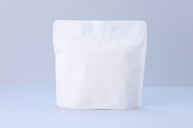 Photo of One zipper stand-up pouch on light grey background. Mockup for design