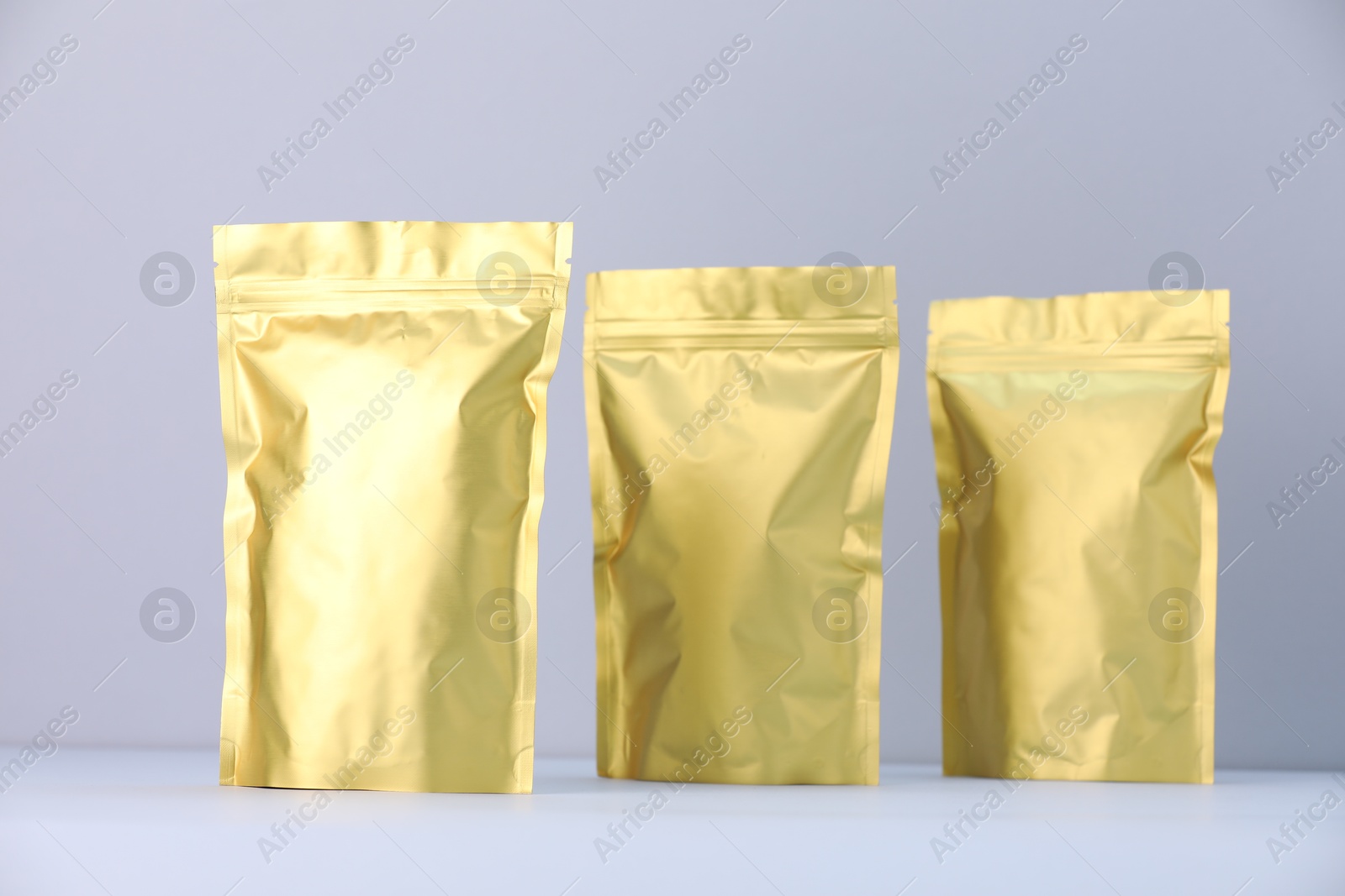 Zipper stand-up pouches on light grey background. Mockup for design Photo of Zipper stand-up pouches on light grey background. Mockup for design