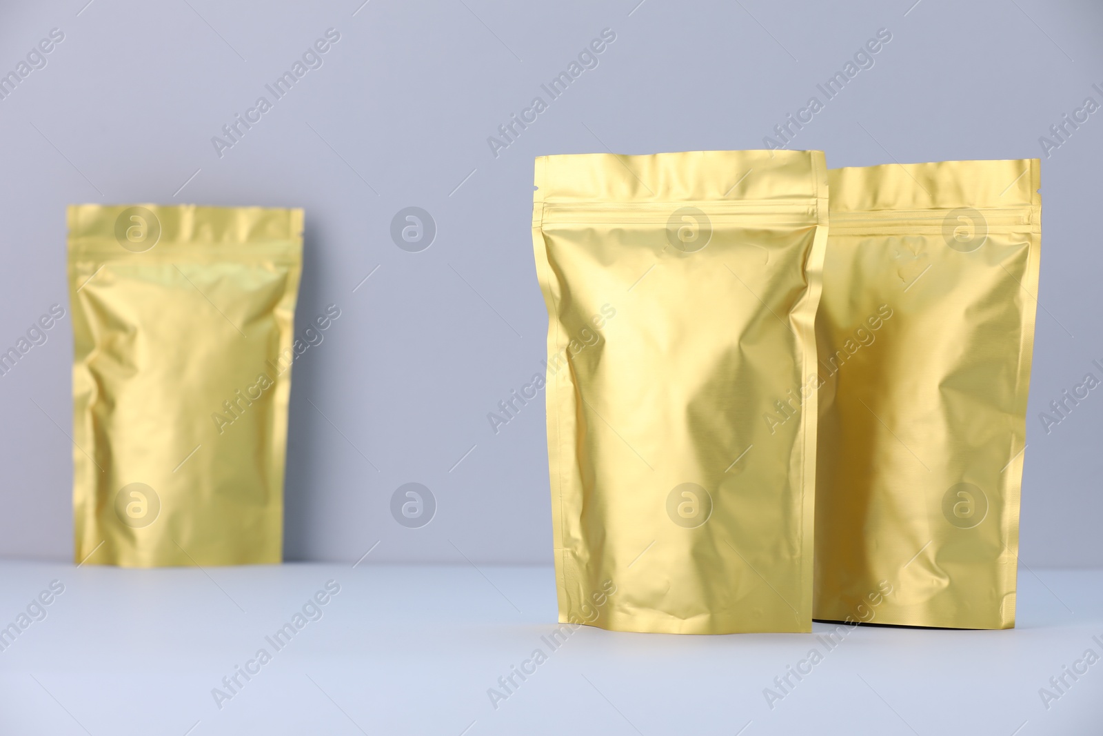 Zipper stand-up pouches on light grey background. Mockup for design Photo of Zipper stand-up pouches on light grey background. Mockup for design