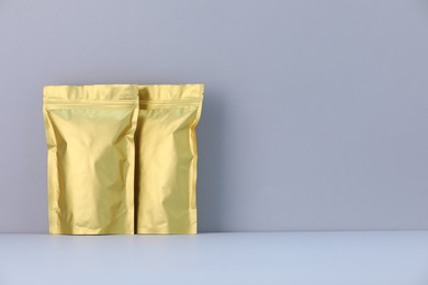 Photo of Two zipper stand-up pouches on light grey background. Mockup for design
