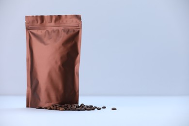 Photo of Zipper stand-up pouch and coffee beans on light grey background. Mockup for design
