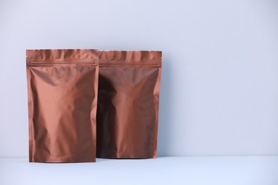 Photo of Two zipper stand-up pouches on light grey background. Mockup for design