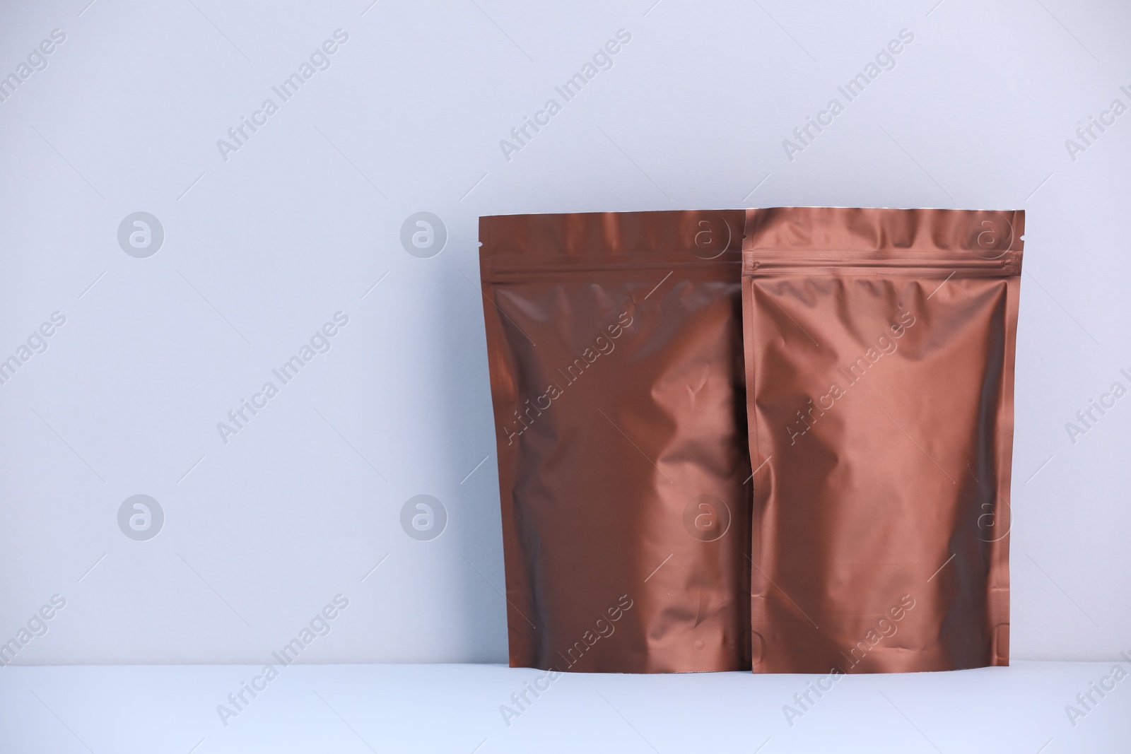 Two zipper stand-up pouches on light grey background. Mockup for design Photo of Two zipper stand-up pouches on light grey background. Mockup for design